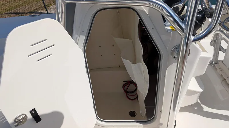 Slide: The Image of 2025 Key West 210 Bay Reef boat storage compartment with open door and visible interior. - 16