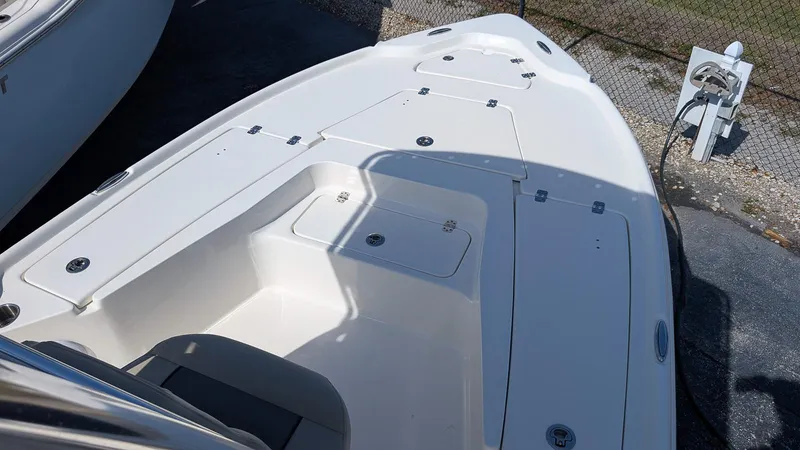 Slide: The Image of 2025 Key West 210 Bay Reef boat deck, featuring storage compartments and sleek design. - 18