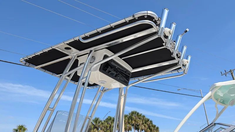 Slide: The Image of 2025 Key West 210 Bay Reef boat with T-top and rod holders against blue sky. - 21
