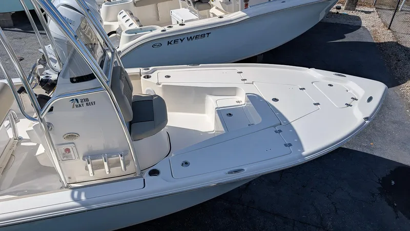 Slide: The Image of 2025 Key West 210 Bay Reef boat, white deck, sleek design, parked outdoors. - 8