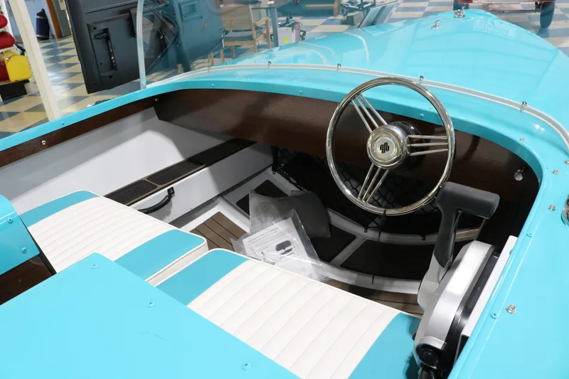 Slide: The Image of Interior of a 2025 Starcraft 57 Ski Champ boat with turquoise and white seating. - 9