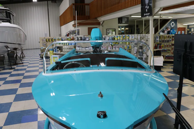 Slide: The Image of 2025 Starcraft 57 Ski Champ boat in showroom, vibrant blue color, nautical equipment displayed. - 13