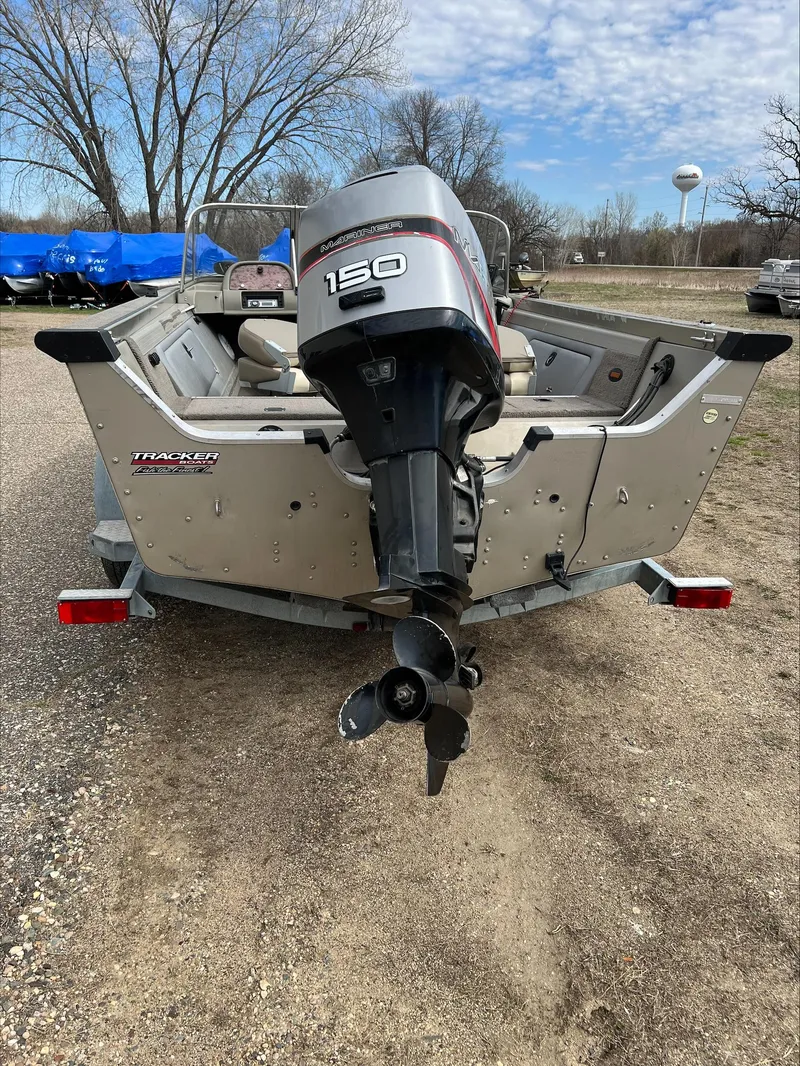 Slide: The Image of 1998 Tracker Targa 185 WT boat with 150 HP outboard motor, parked on gravel. - 12