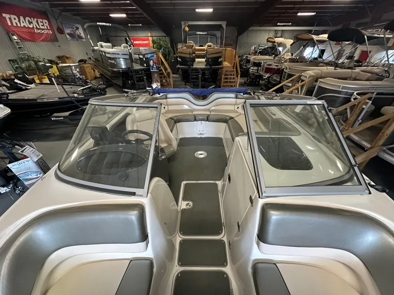 Slide: The Image of 2009 Yamaha SX210 boat interior in showroom, featuring dual consoles and spacious seating. - 12