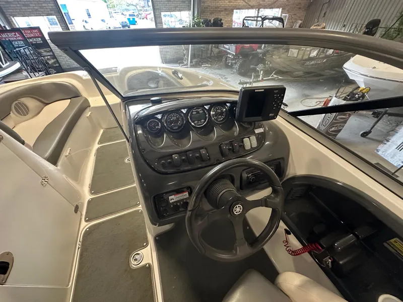 Slide: The Image of 2009 Yamaha Boats SX210 dashboard with steering wheel and control panel in a showroom. - 13
