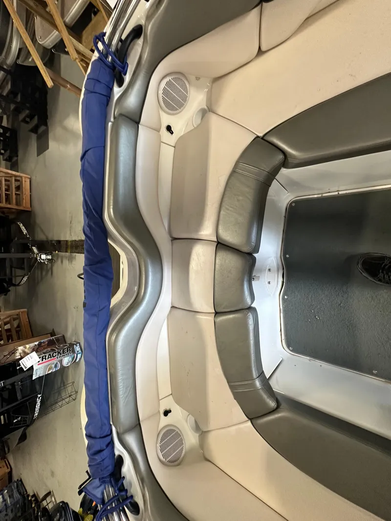 Slide: The Image of 2009 Yamaha Boats SX210 interior seating with blue cover in a garage setting. - 16