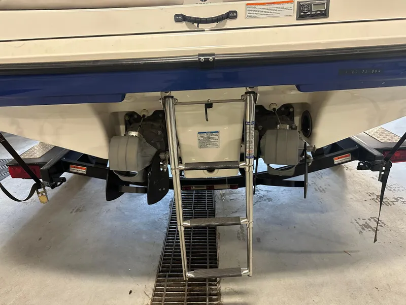 Slide: The Image of 2009 Yamaha Boats SX210 rear view with ladder and dual engines in a garage setting. - 24