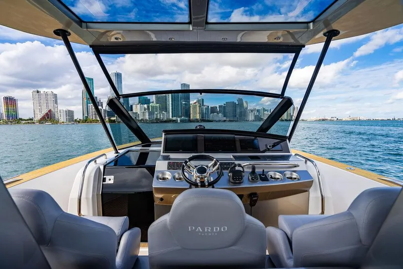 Slide: The Image of 2022 Pardo Yachts 43 cockpit with city skyline view, featuring modern steering and controls. - 12