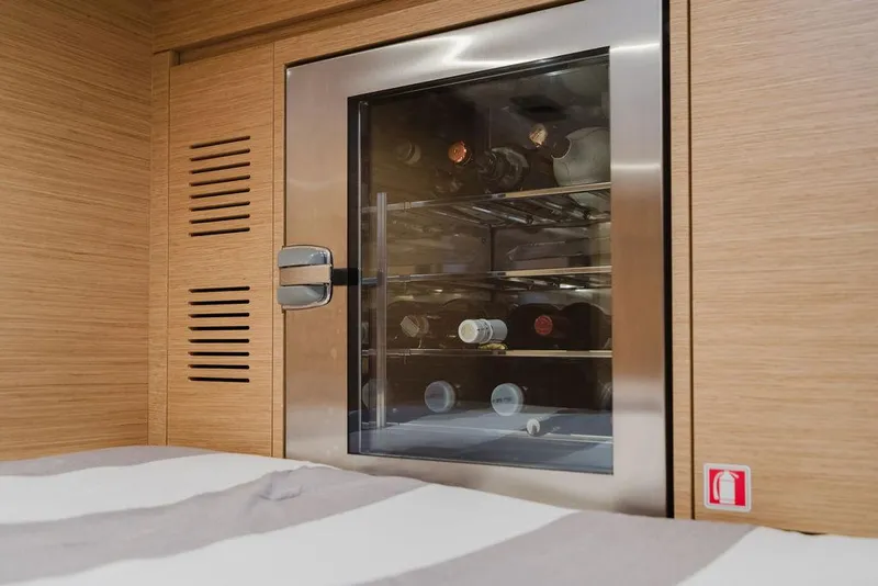 Slide: The Image of Wine cooler inside 2022 Pardo Yachts 43, featuring wooden cabinetry and stainless steel finish. - 6