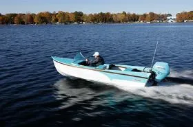 Slide: The Image of 2025 Starcraft 57 SKI CHAMP boat cruising on a lake with autumn trees in the background. - 10