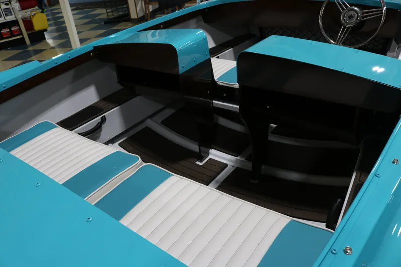 Slide: The Image of Interior of a 2025 Starcraft 57 Ski Champ boat with turquoise and white seating. - 7