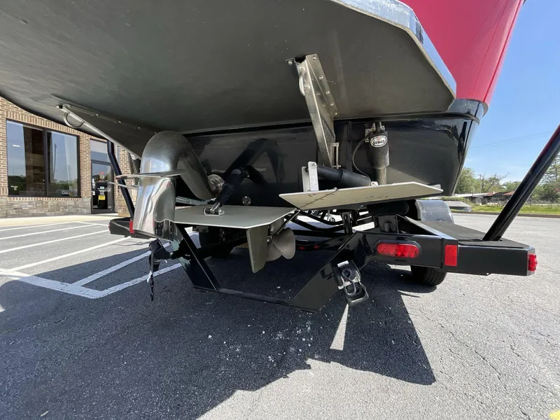 Slide: The Image of 2023 Moomba Craz boat rear view showing propeller and rudder in a parking lot. - 12