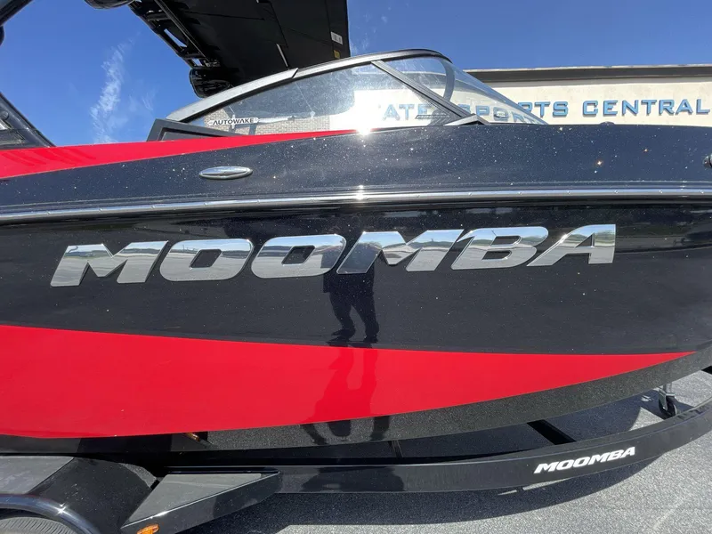 Slide: The Image of 2023 Moomba Craz boat with red and black design, side view. - 17