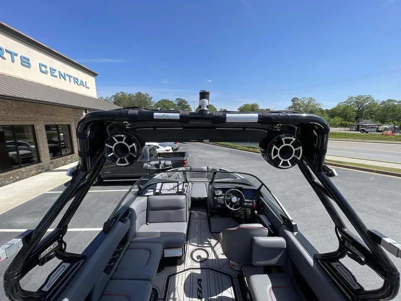 Slide: The Image of 2023 Moomba Craz boat interior with speakers, parked outside a building under a clear blue sky. - 24