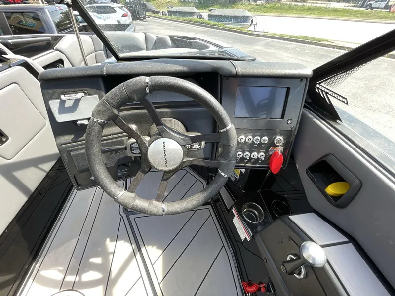 Slide: The Image of 2023 Moomba Craz boat dashboard with steering wheel, touchscreen, and control panel. - 34
