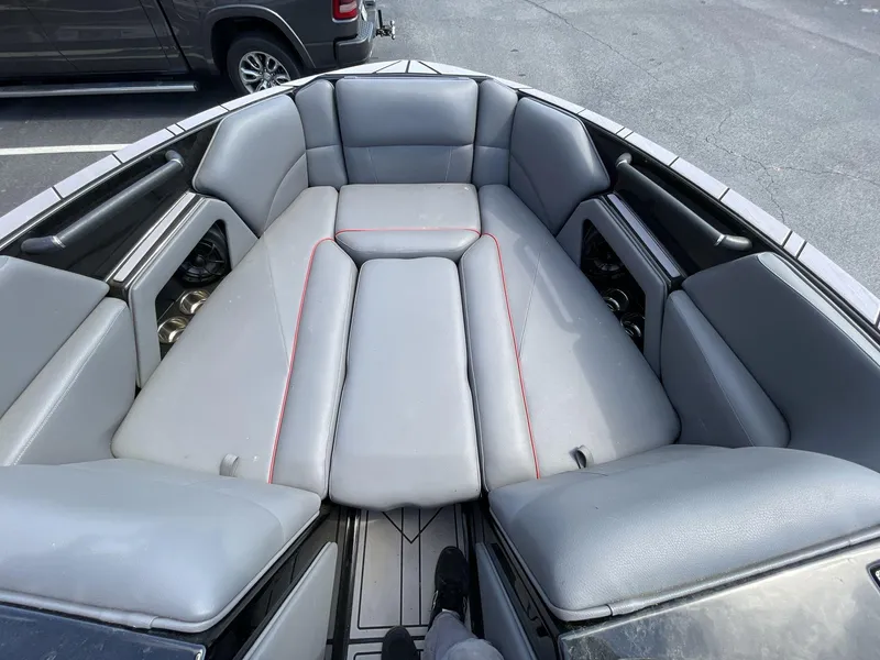 Slide: The Image of 2023 Moomba Craz boat interior with gray cushioned seating and red stitching. - 39