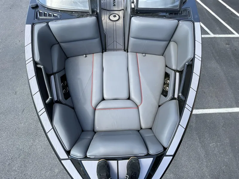 Slide: The Image of 2023 Moomba Craz boat interior with gray seating and red stitching, viewed from above. - 40