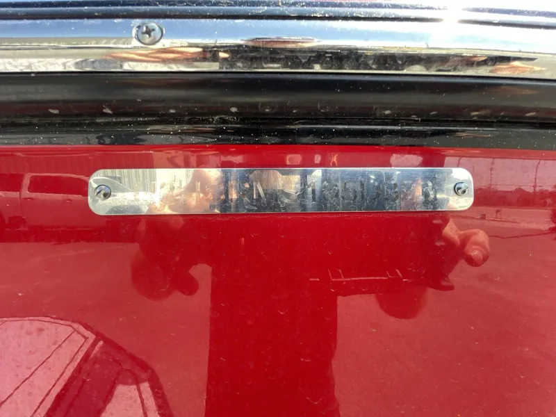 Slide: The Image of 2023 Moomba Craz boat with red exterior and chrome detailing. - 7