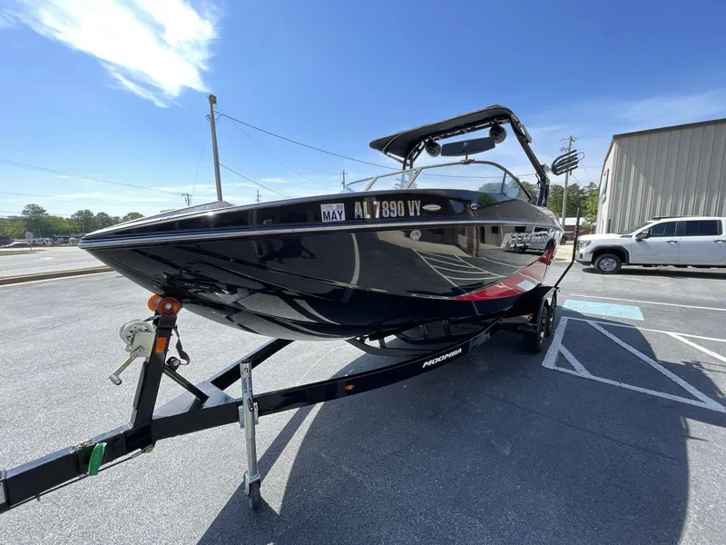 Slide: The Image of 2023 Moomba Craz boat on trailer in parking lot under clear blue sky. - 8