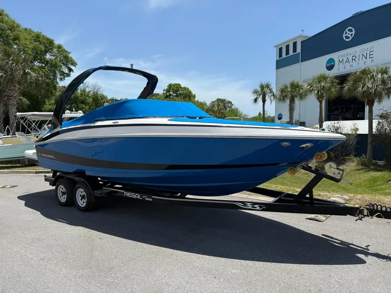 Slide: The Image of 2011 Regal 2500 Bowrider boat on trailer, parked near marine building, sunny day. - 10