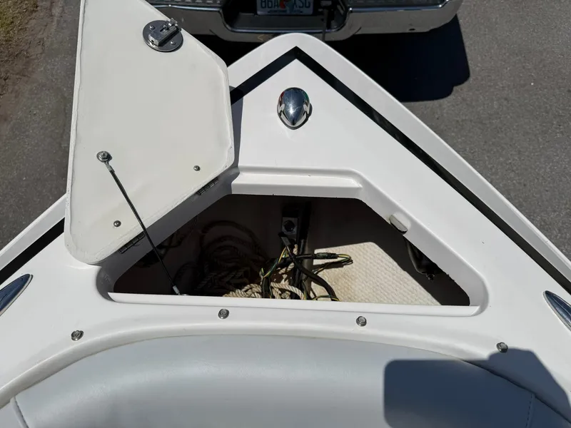 Slide: The Image of 2011 Regal 2500 Bowrider boat with open storage compartment, showing ropes and accessories. - 11