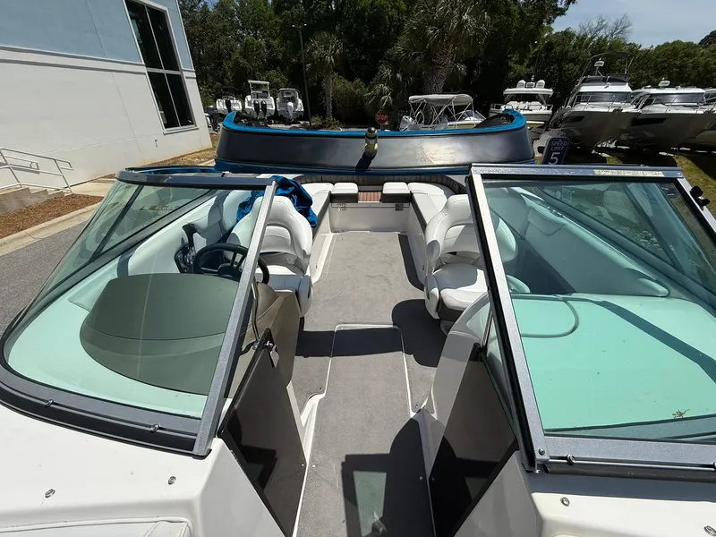 Slide: The Image of 2011 Regal 2500 Bowrider boat with spacious seating and dual windshields, docked outdoors. - 12