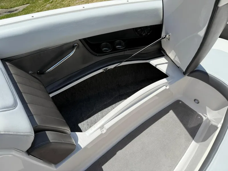 Slide: The Image of 2011 Regal 2500 Bowrider interior storage compartment with open seat and carpeted flooring. - 15