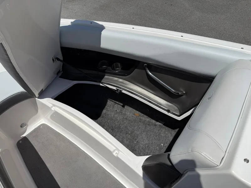 Slide: The Image of 2011 Regal 2500 Bowrider interior storage compartment with open seat and carpeted floor. - 17