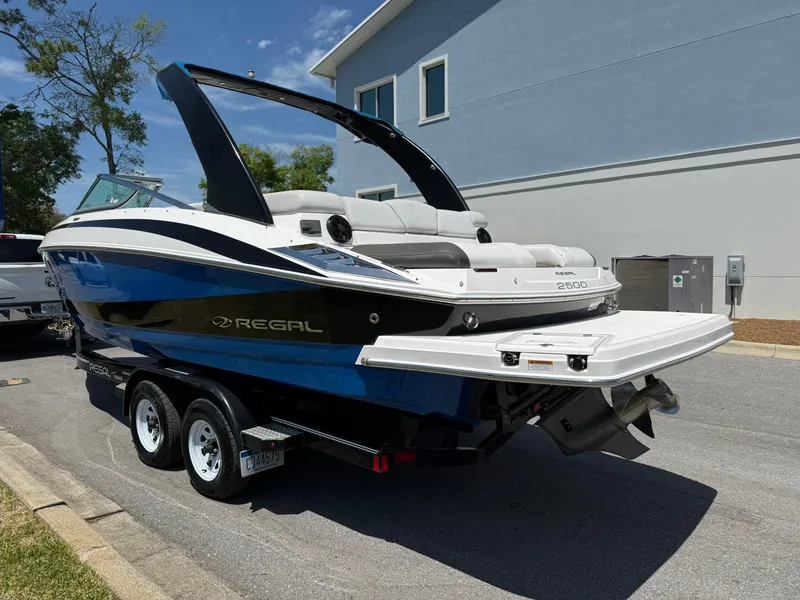Slide: The Image of 2011 Regal 2500 Bowrider boat on trailer, parked outdoors, sunny day. - 2