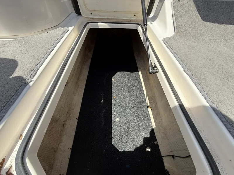 Slide: The Image of 2011 Regal 2500 Bowrider storage compartment, open and empty, with carpeted interior. - 20