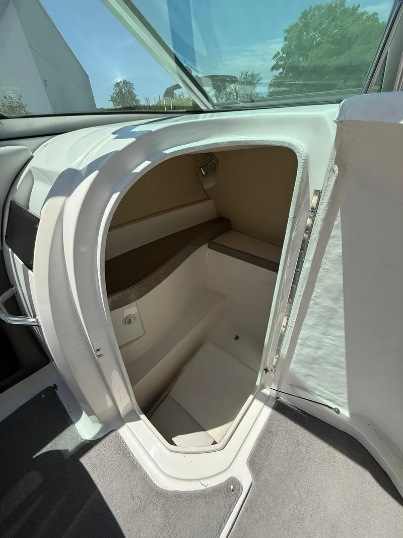 Slide: The Image of 2011 Regal 2500 Bowrider interior storage compartment with open door, showcasing spacious design. - 30