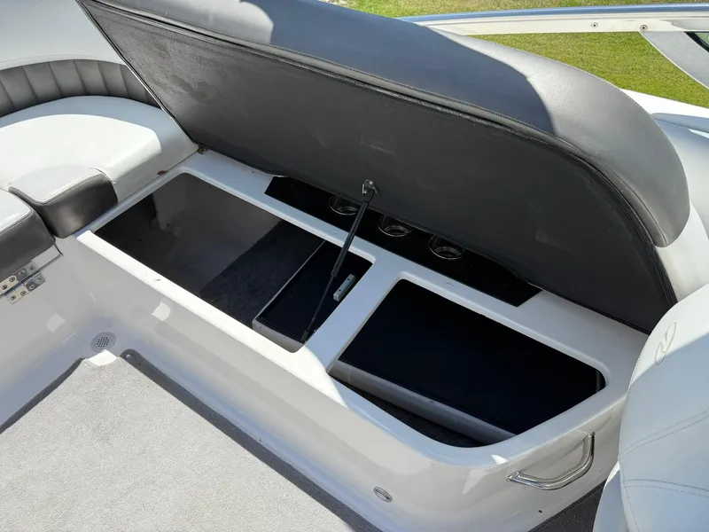 Slide: The Image of 2011 Regal 2500 Bowrider boat storage compartment with open seat revealing spacious interior. - 33