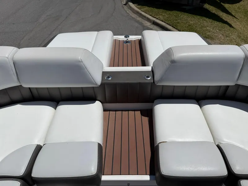 Slide: The Image of 2011 Regal 2500 Bowrider boat interior with white cushioned seating and wooden flooring. - 34