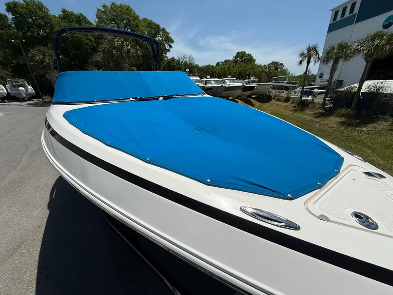 Slide: The Image of 2011 Regal 2500 Bowrider with blue cover, parked outdoors on a sunny day. - 5