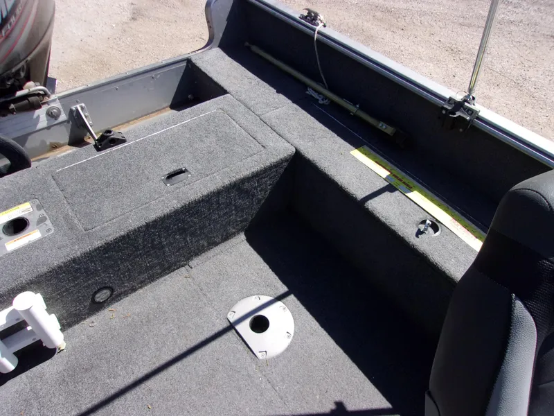 Slide: The Image of Interior of a 2017 Lund 1775 Impact Sport boat, featuring carpeted seating and storage areas. - 10
