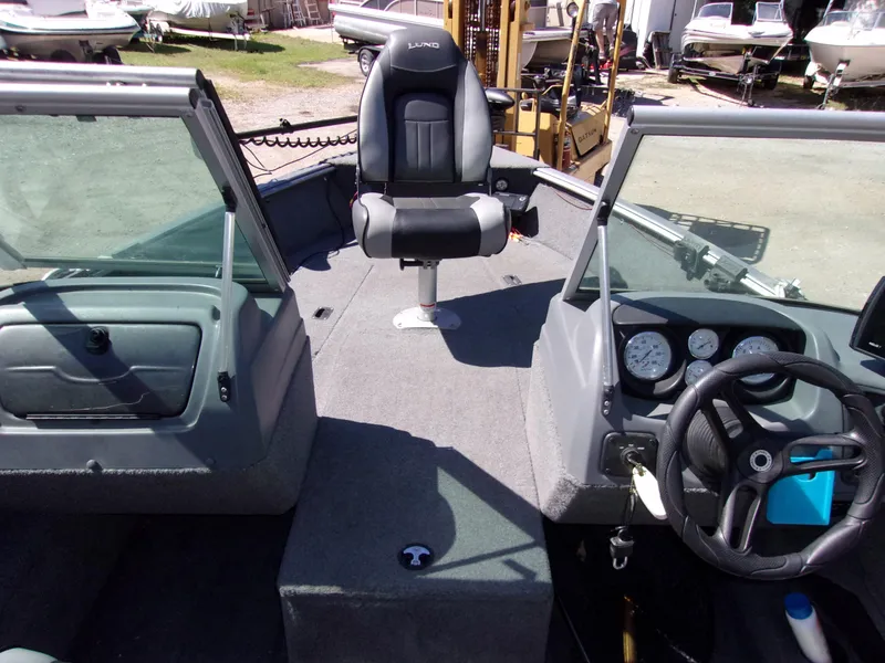 Slide: The Image of 2017 Lund 1775 Impact Sport boat interior with steering wheel and seating. - 11