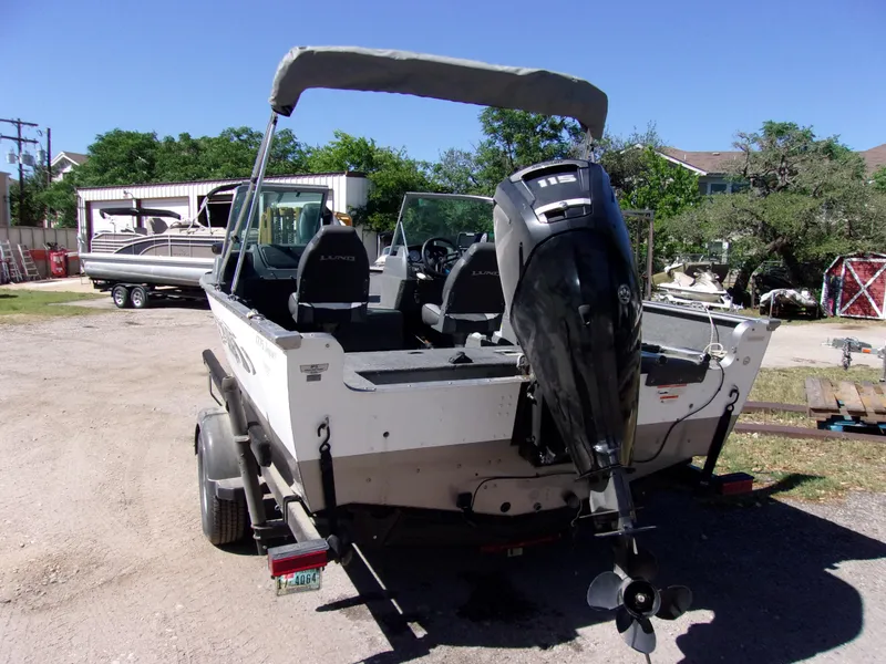 Slide: The Image of 2017 Lund 1775 Impact Sport boat with outboard motor on trailer, parked outdoors. - 4