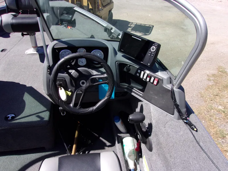 Slide: The Image of 2017 Lund 1775 Impact Sport boat dashboard with steering wheel and control panel. - 5