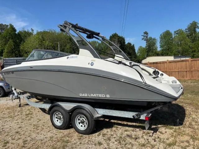 Slide: The Image of 2016 Yamaha Boats 242 Limited S on trailer, parked outdoors on grass. - 2