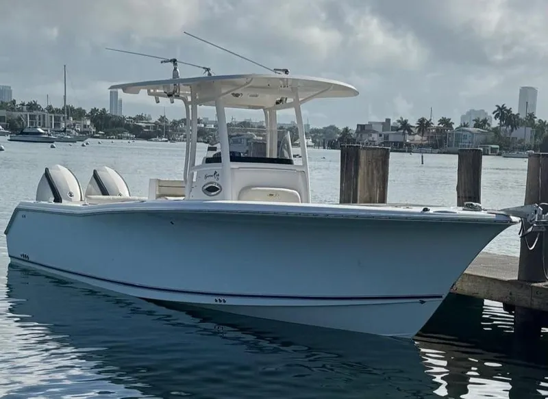 Slide: The Image of 2013 Sea Hunt Gamefish 29 boat docked in a marina with city skyline. - 0