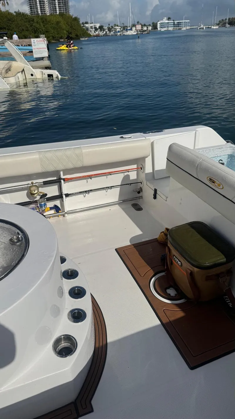 Slide: The Image of 2013 Sea Hunt Gamefish 29 boat interior with fishing gear, docked by calm waters. - 12