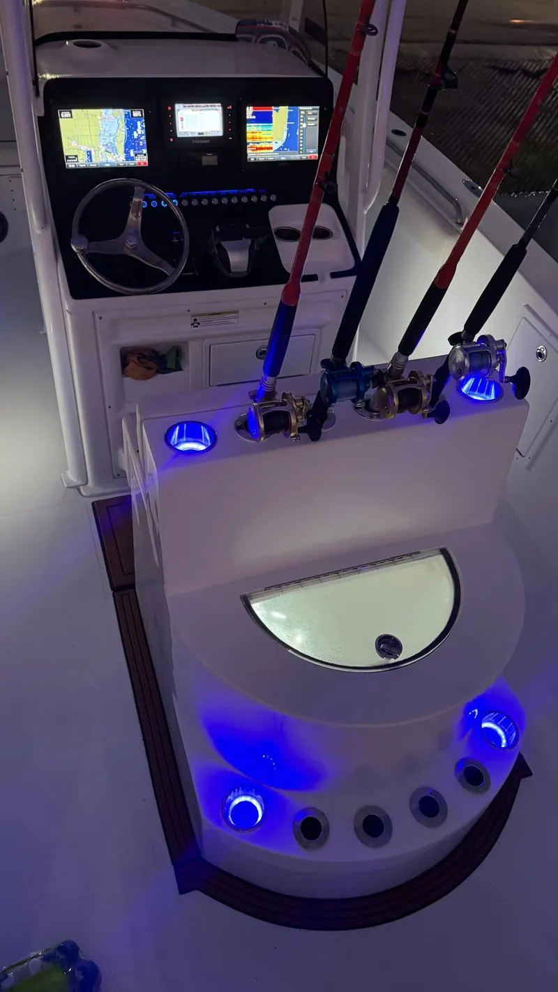 Slide: The Image of 2013 Sea Hunt Gamefish 29 boat cockpit with illuminated fishing rod holders and navigation display. - 14