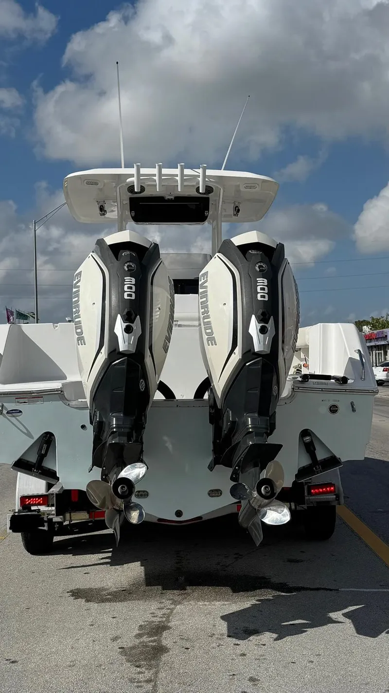 Slide: The Image of 2013 Sea Hunt Gamefish 29 with dual outboard engines, parked on a sunny day. - 2