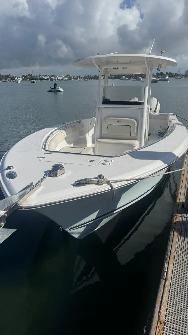Slide: The Image of 2013 Sea Hunt Gamefish 29 boat docked on calm water under cloudy sky. - 5