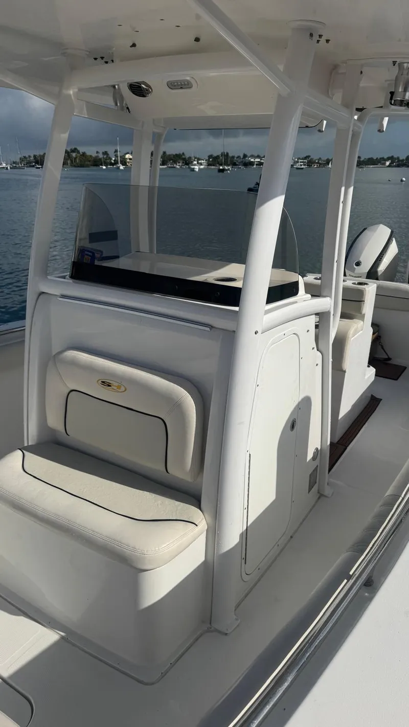 Slide: The Image of 2013 Sea Hunt Gamefish 29 boat interior with seating and console, on calm water. - 6
