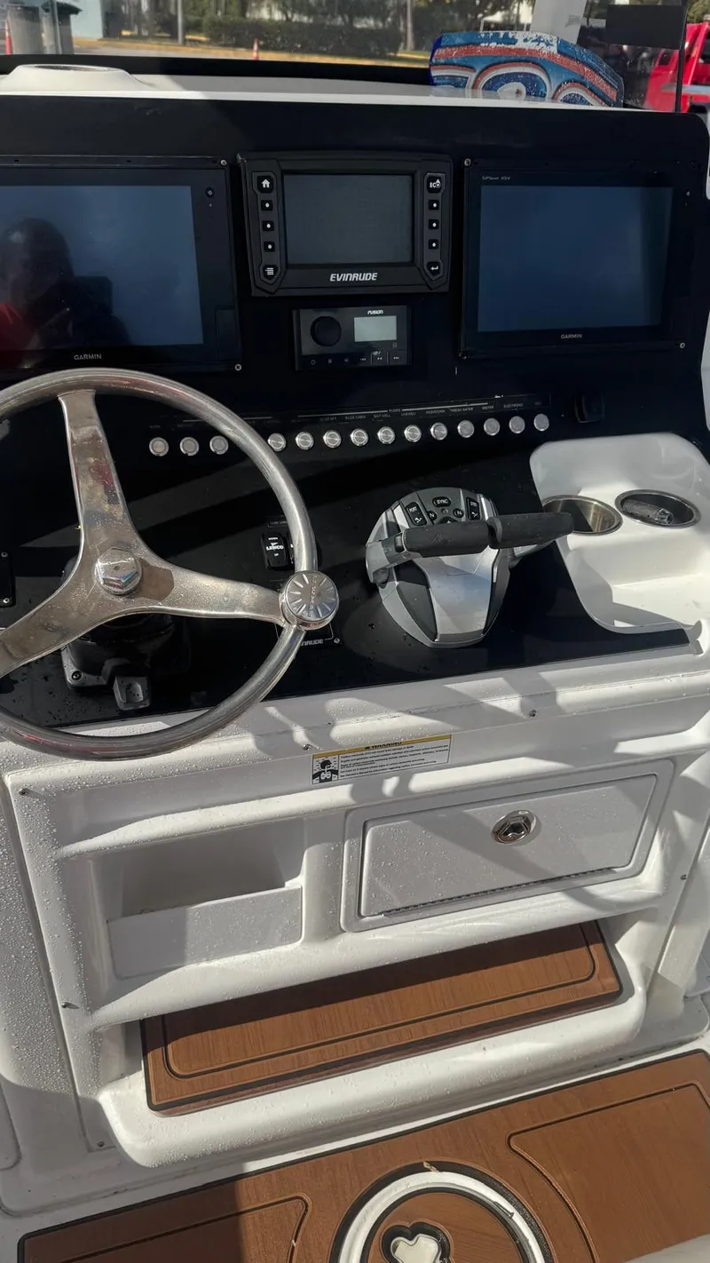 Slide: The Image of 2013 Sea Hunt Gamefish 29 helm with dual screens and steering wheel. - 9