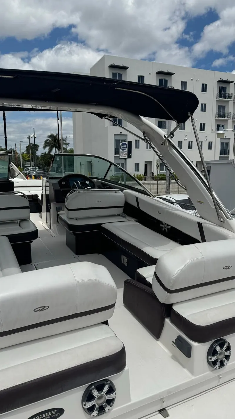 Slide: The Image of 2017 Regal 29 OBX boat with spacious seating, modern design, and urban backdrop. - 11
