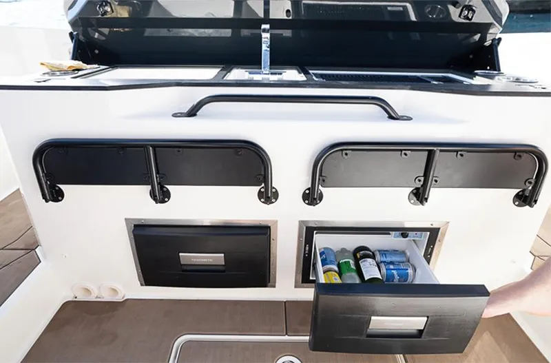 Slide: The Image of Navan S30 2025 boat interior with open storage compartments and beverage drawer. - 8