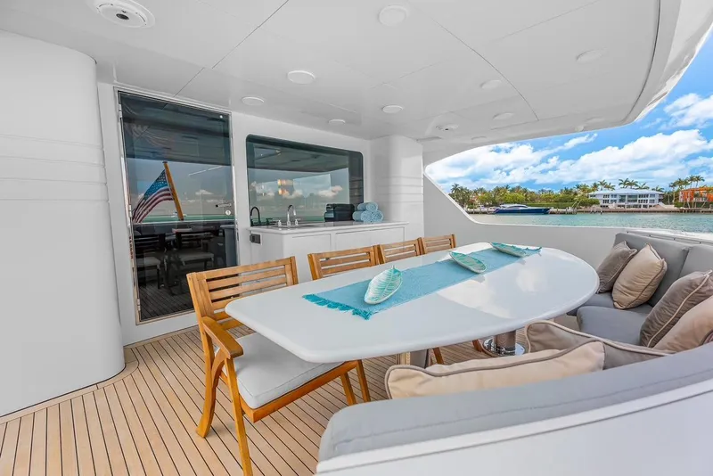 Slide: The Image of Luxury yacht deck with dining area, featuring wooden chairs and a white table, Intermarine RPH 95, 2001. - 11