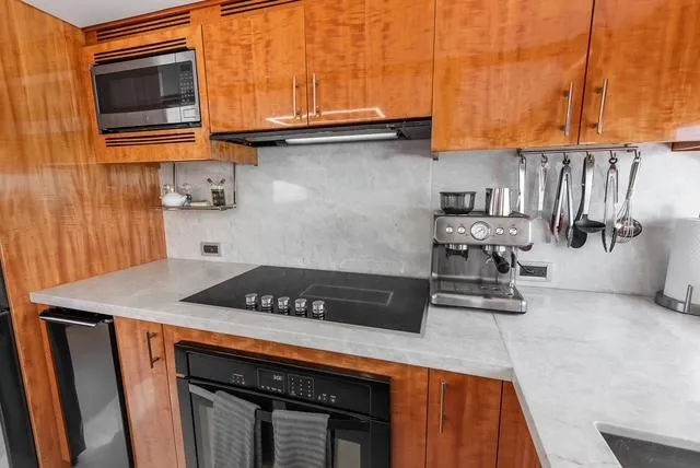 Slide: The Image of Luxurious kitchen in 2001 Intermarine RPH 95 yacht with modern appliances and wooden cabinetry. - 28